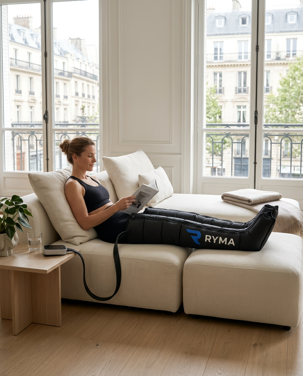 Femme allongée sur un canapé utilisant les bottes de pressothérapie RYMA à domicile