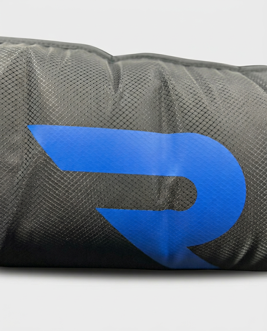 Gros plan sur le tissu technique d'une botte RYMA et son logo bleu